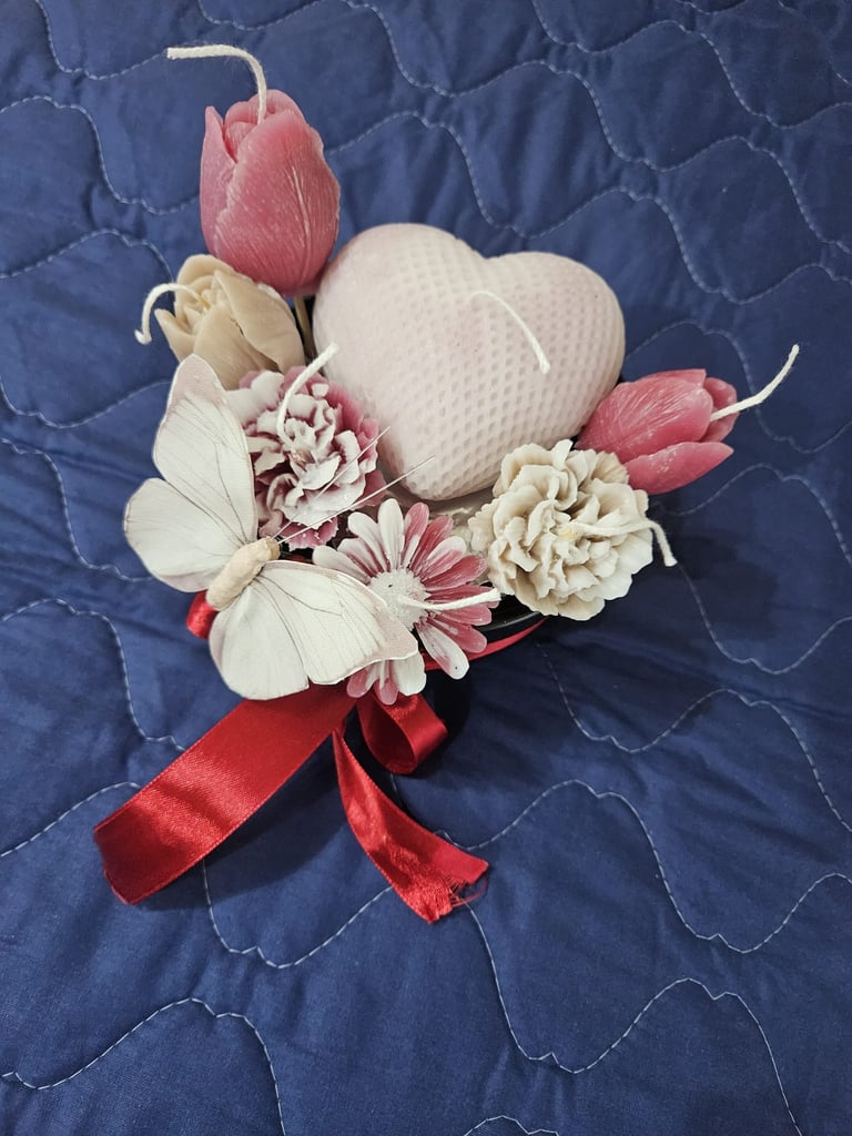 Handmade decorative soy wax candles shaped like a heart, tulips, and a butterfly with a red bow.