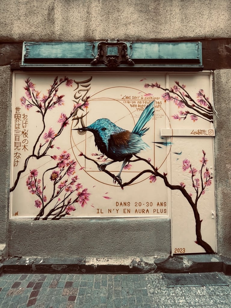 un graffiti avec un oiseau sur une branche et des fleurs roses