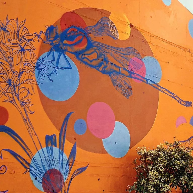 une fresque d'une libellule bleu sur fond orange