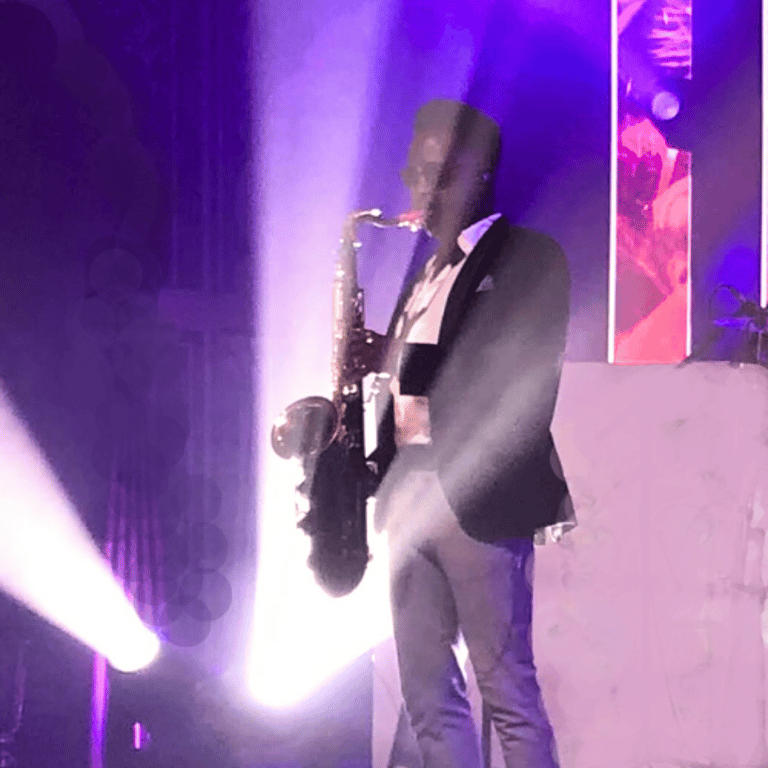 Saxophonist playing at a party with spotlights and shadows looking cool