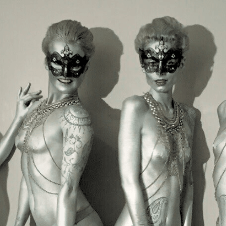 silver painted body models with masquerade masks and body chains