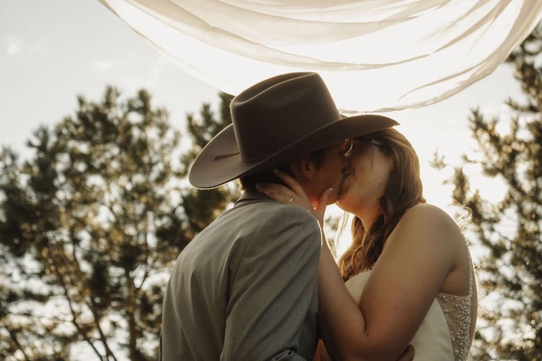 bride and groom portrait, kissing, sunlight