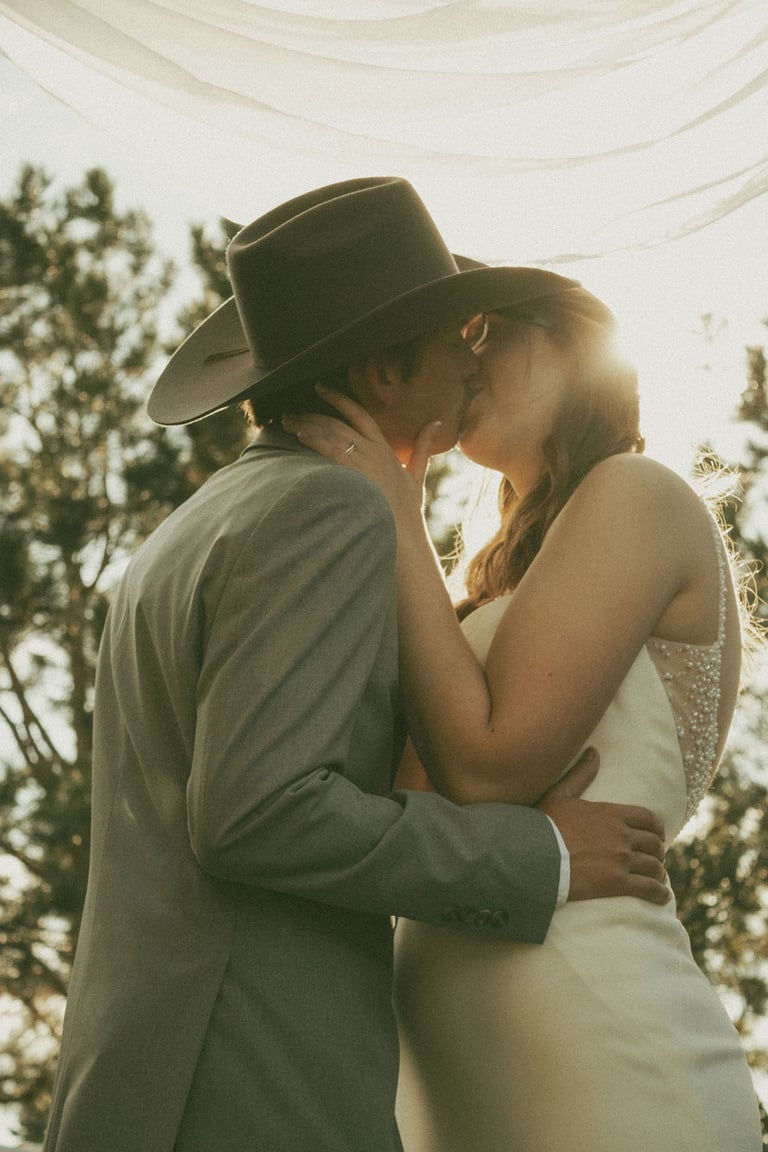 bride and groom portrait, kissing, sunlight