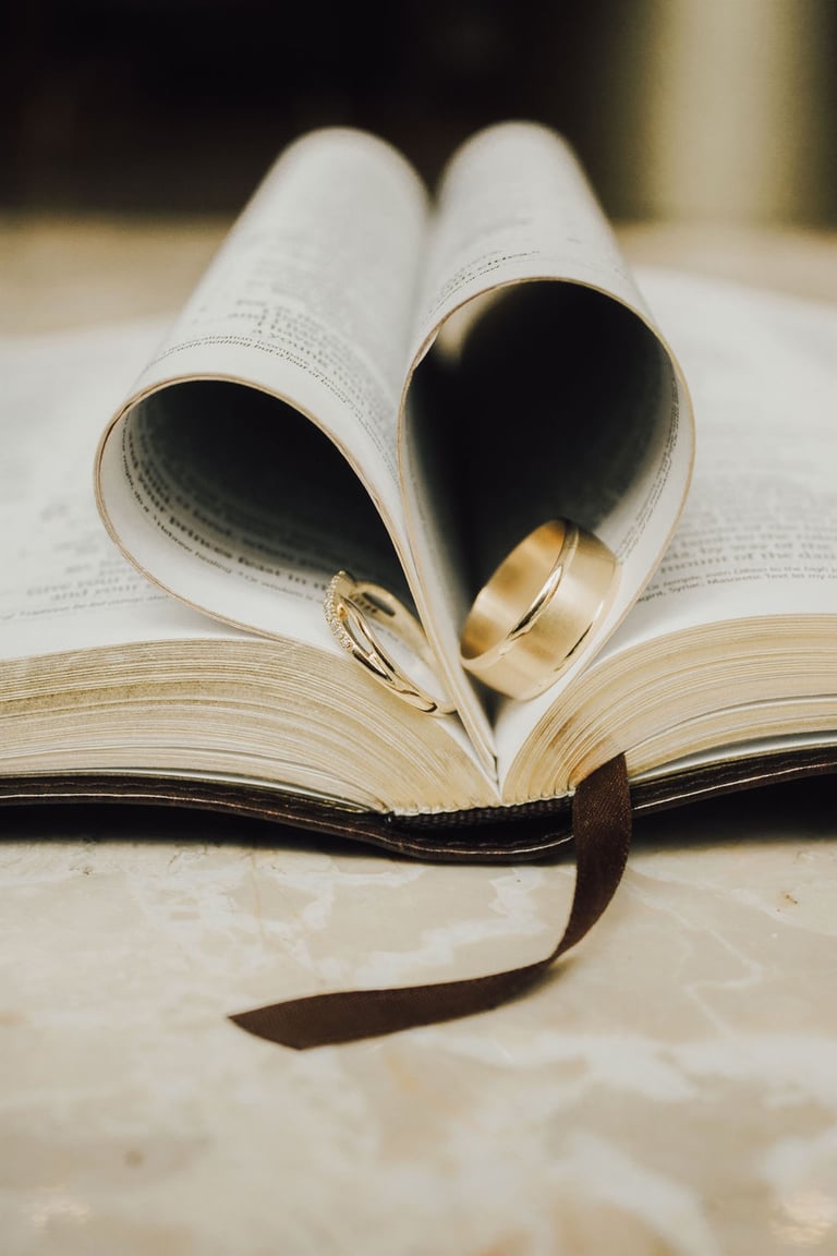 bible flat lay, pages folded into a heart, wedding bands