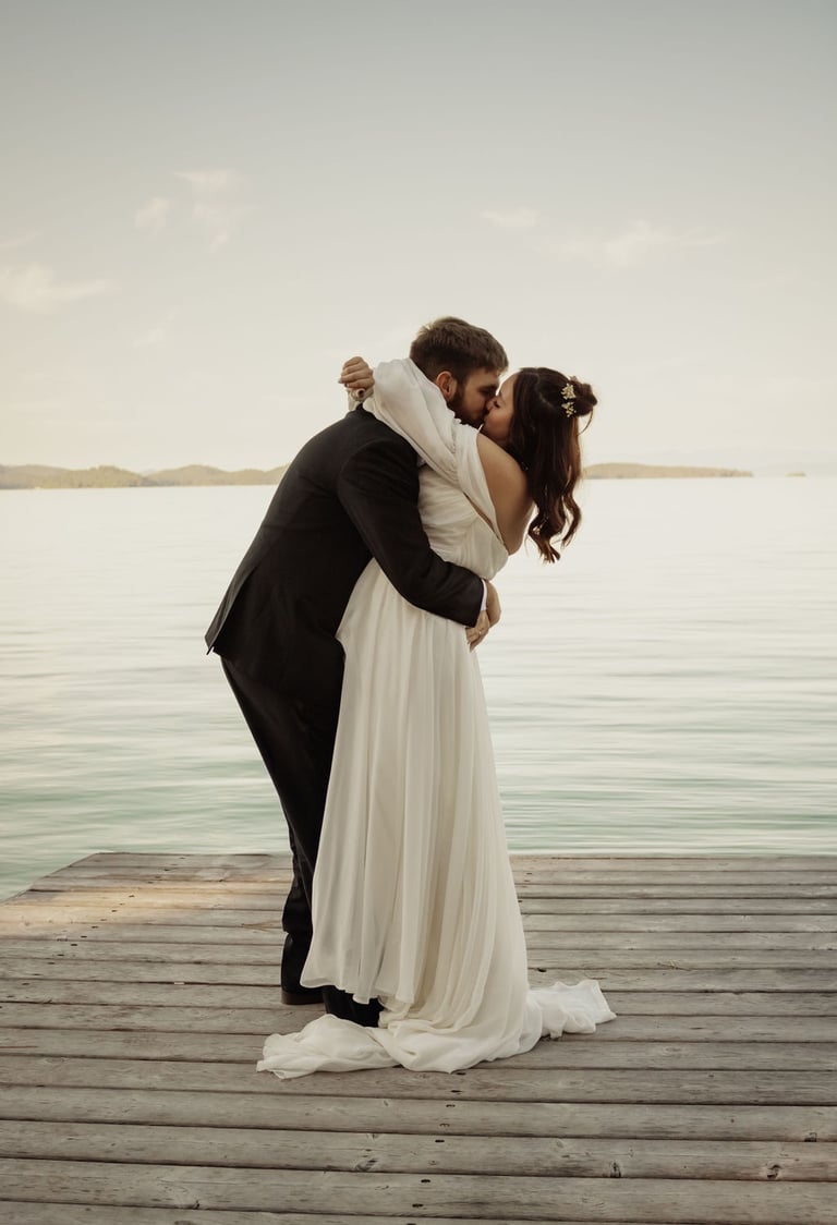bride and groom portrait, kissing on a dock on Flathead Lake