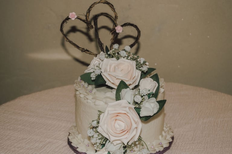 wedding cake with pink roses and hearts