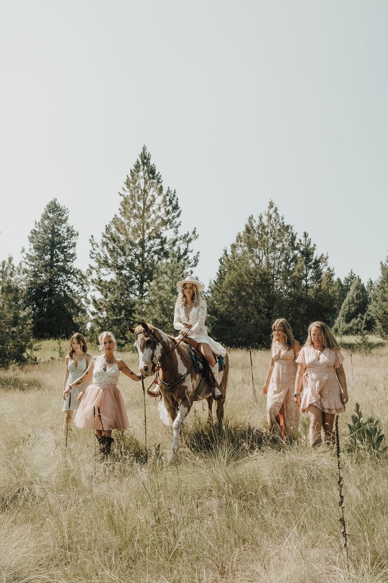 bridesmaid photos, bride riding paint horse, field, pine trees, Big Arm State Park