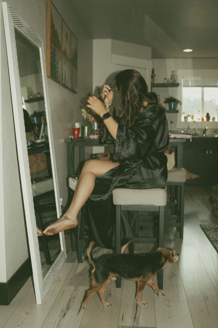 bride getting ready, sitting on stool in front of mirror