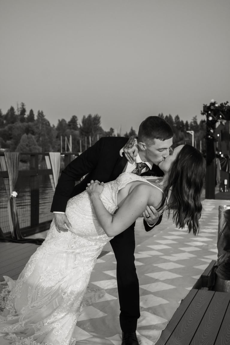 black and white photo of bride and groom, kissing, dip on the aisle, house boat