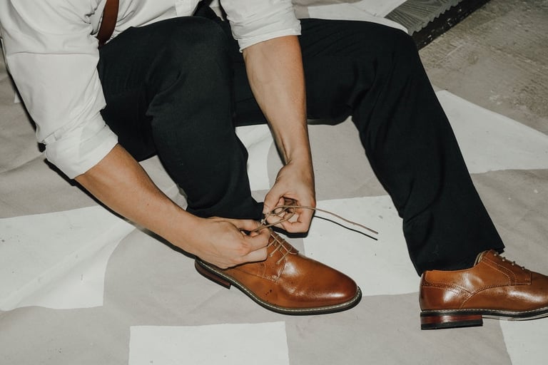 detail shot of groomsman tying his shoes
