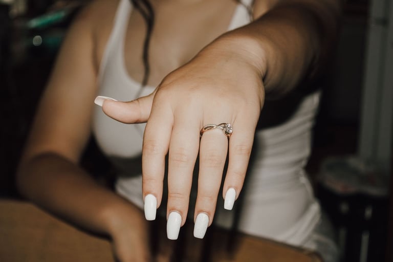 detail shot of bride's hand with engagement ring, white nails