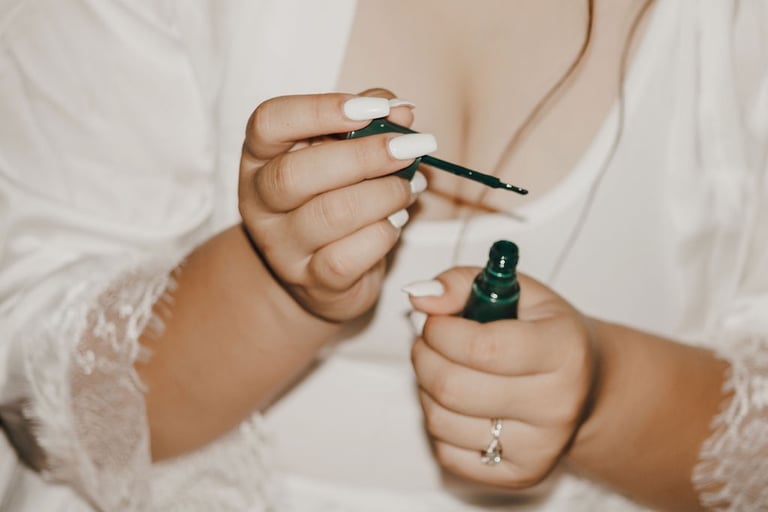 detail photo of bride's hands, white nails, green nail polish, engagement ring