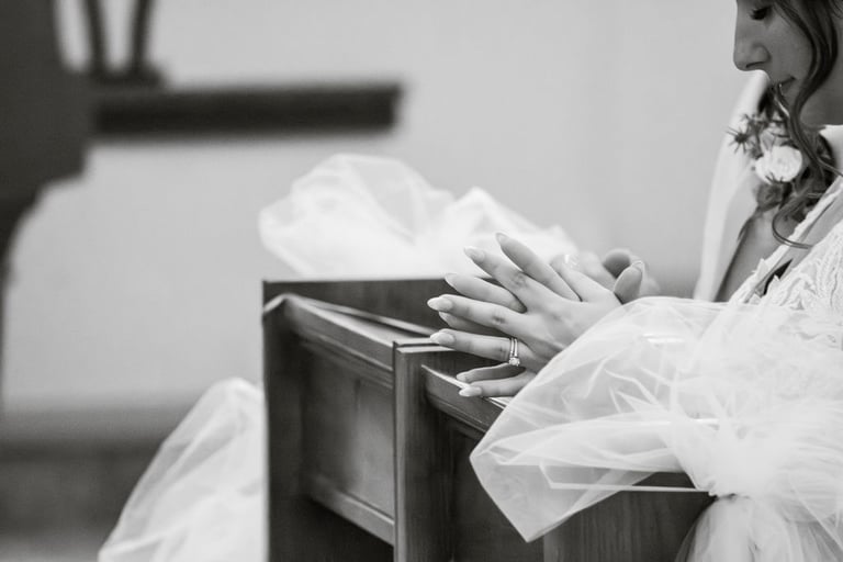 black and white closeup of bride praying during Catholic ceremony, wedding ring