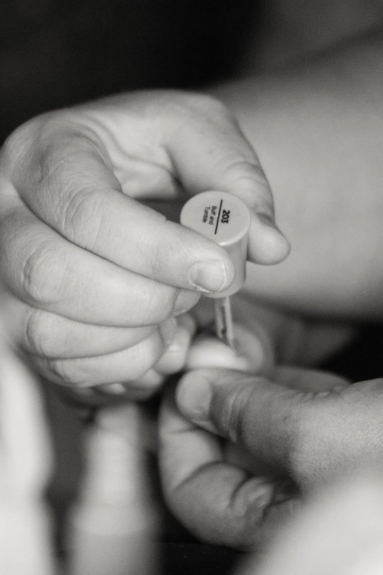 black and white closeup of mother painting child's toe nails