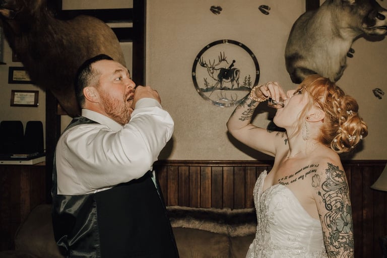 bride and groom taking alcohol shots post ceremony