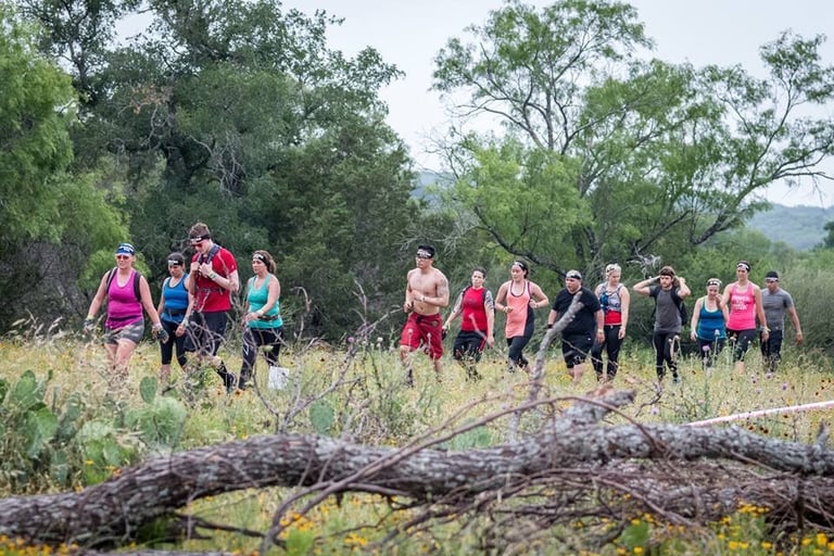 a group of people walking on a trail during a spartan race