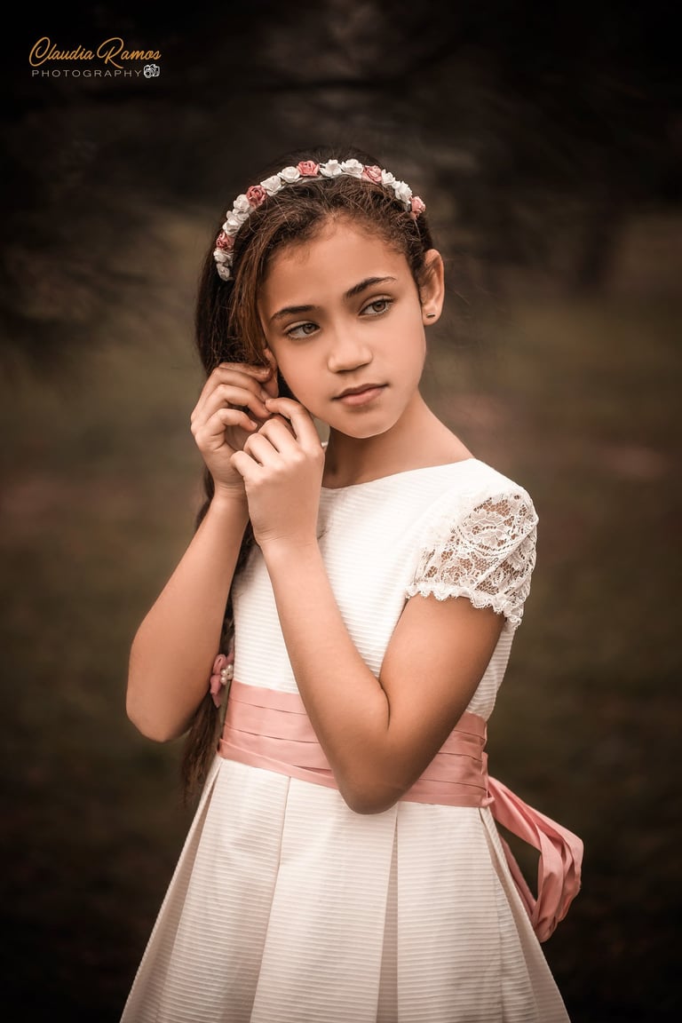 niña de comunión tocándo su orejita