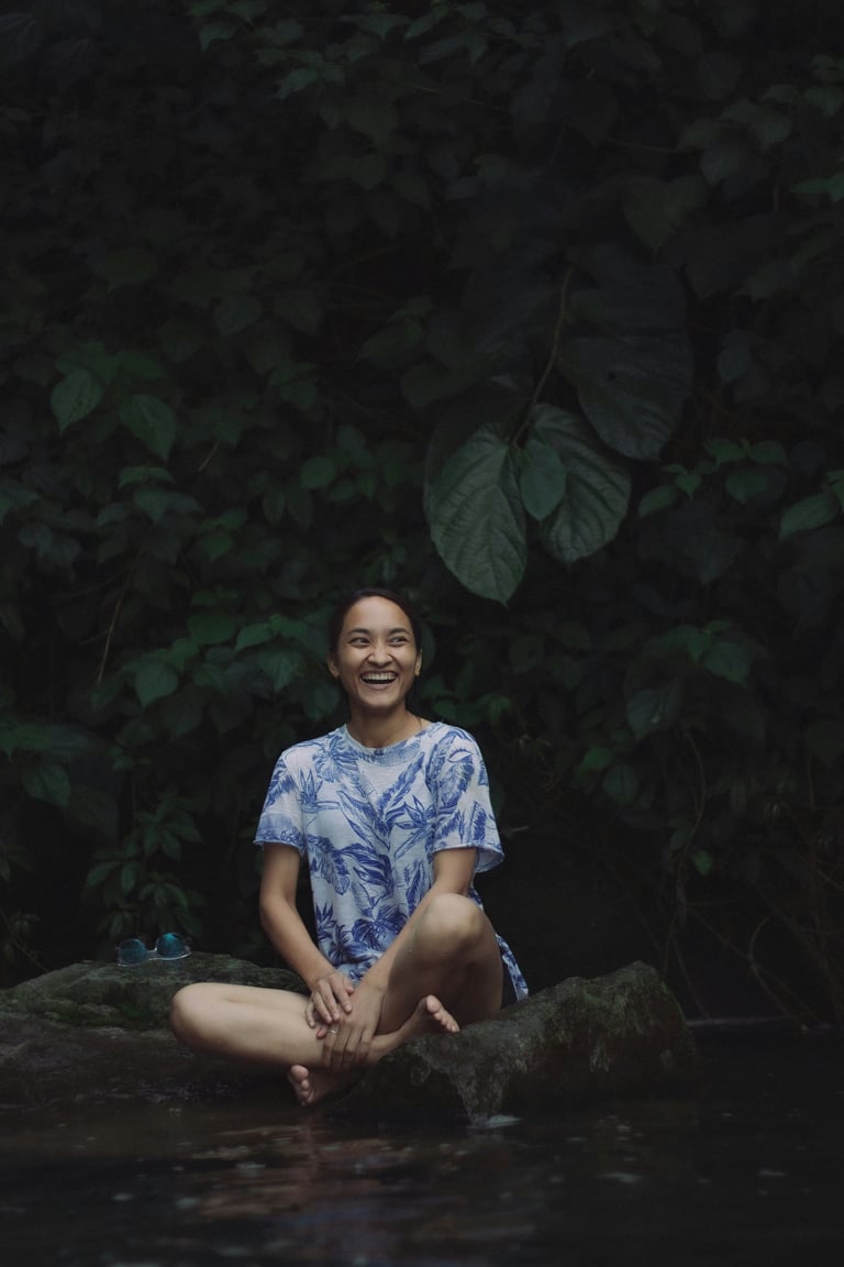 woman in nature smiling in meditation pose