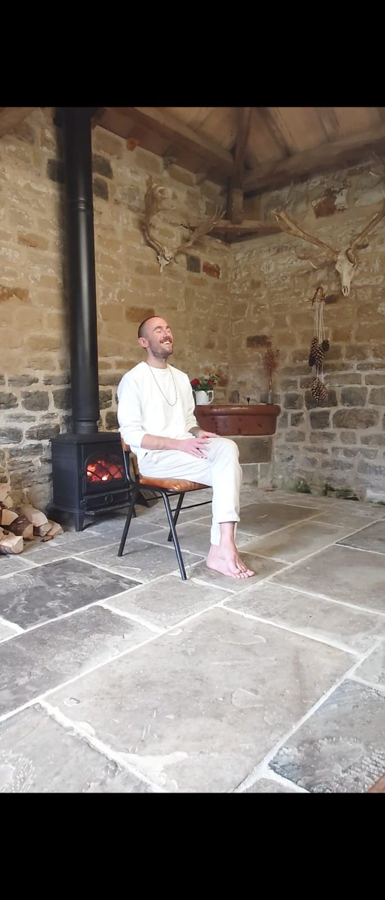 a man dressed in all white wearing meditation beads