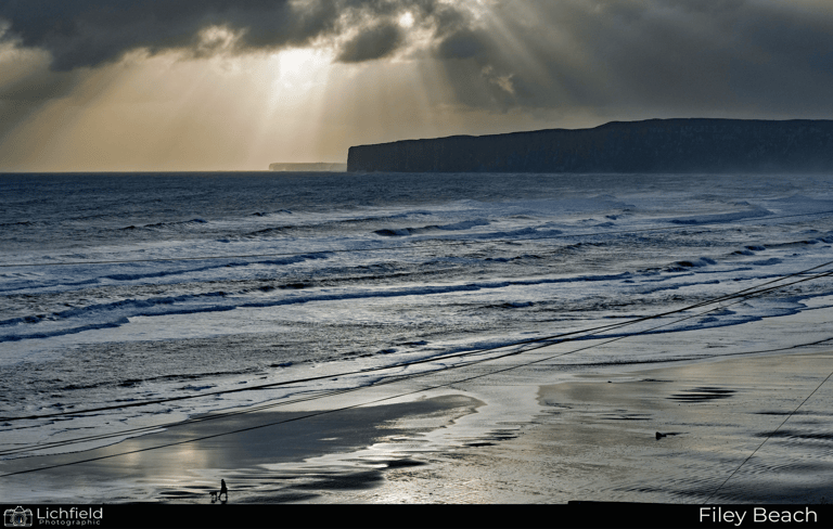 A sunrise beach with hills in the distance 