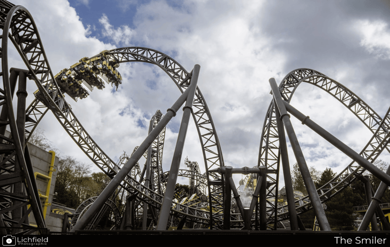 A Roller coaster in the shape of eyes and a smile with a cart on a loop to the left