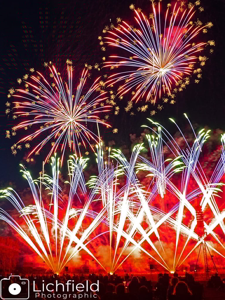 Two firework bursts with Roman Candles
