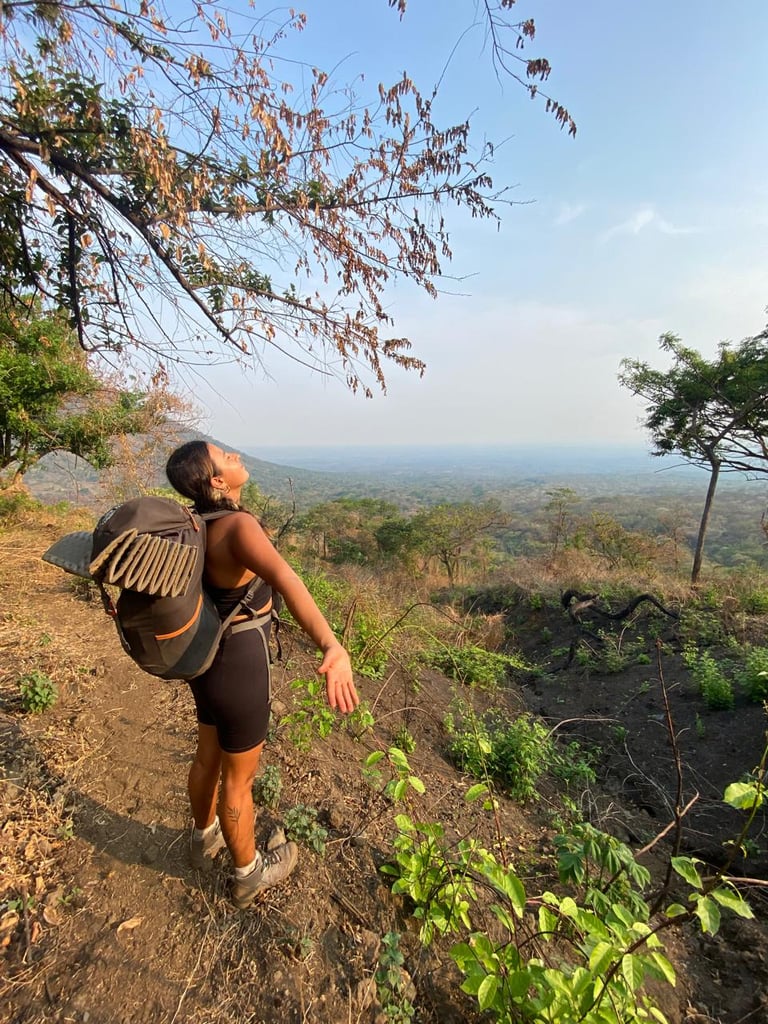 Una aventurera con mochila disfruta de una vista panorámica de la montaña mientras recorre un sen