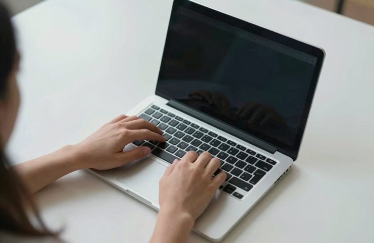 Top-down view of a person working on a clean, professional laptop, soft light blue and off-white tones, minimalist environment.