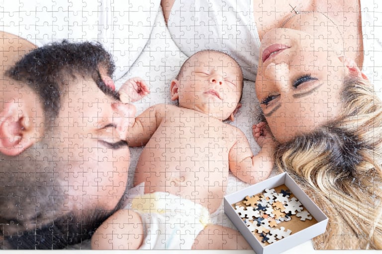 The father, mother, and their newborn baby are lying in bed.