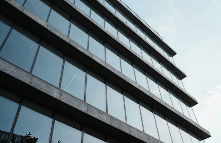 A low-angle shot of a modern architectural structure with clean lines and glass windows, reflecting a pale blue sky, symbolizing innovation and growth in an International / English-speaking market.