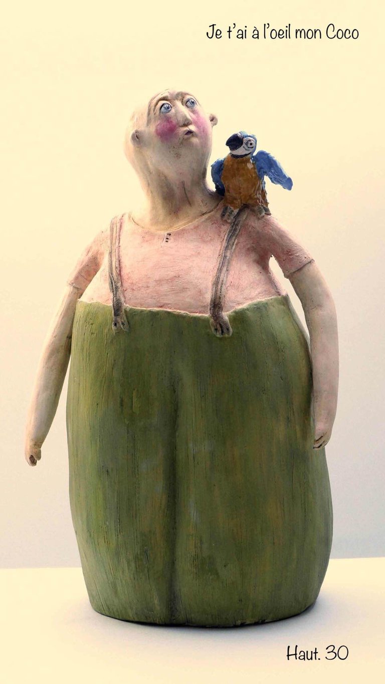 sculpture terre homme pantalon vert bretelles surveille perroquet Ara malicieux intitulée Je t'ai à l'oeil mon Coco