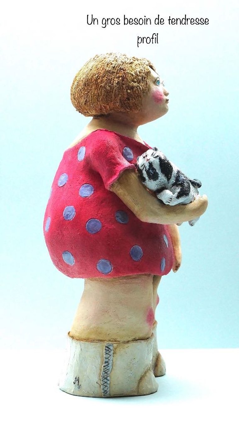 sculpture terre femme robe rouge bottes blanches tenant chat noir et blanc intitulée Un gros besoin de tendresse