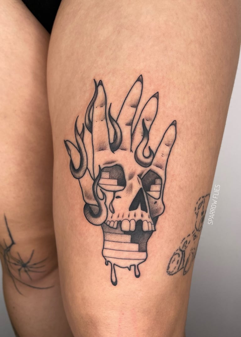 Neo-traditional hand, flames and skull tattoo on the leg
