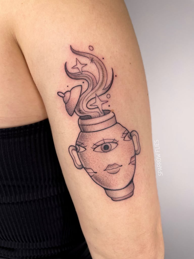 Fine-line vase tattoo with face and sparkles