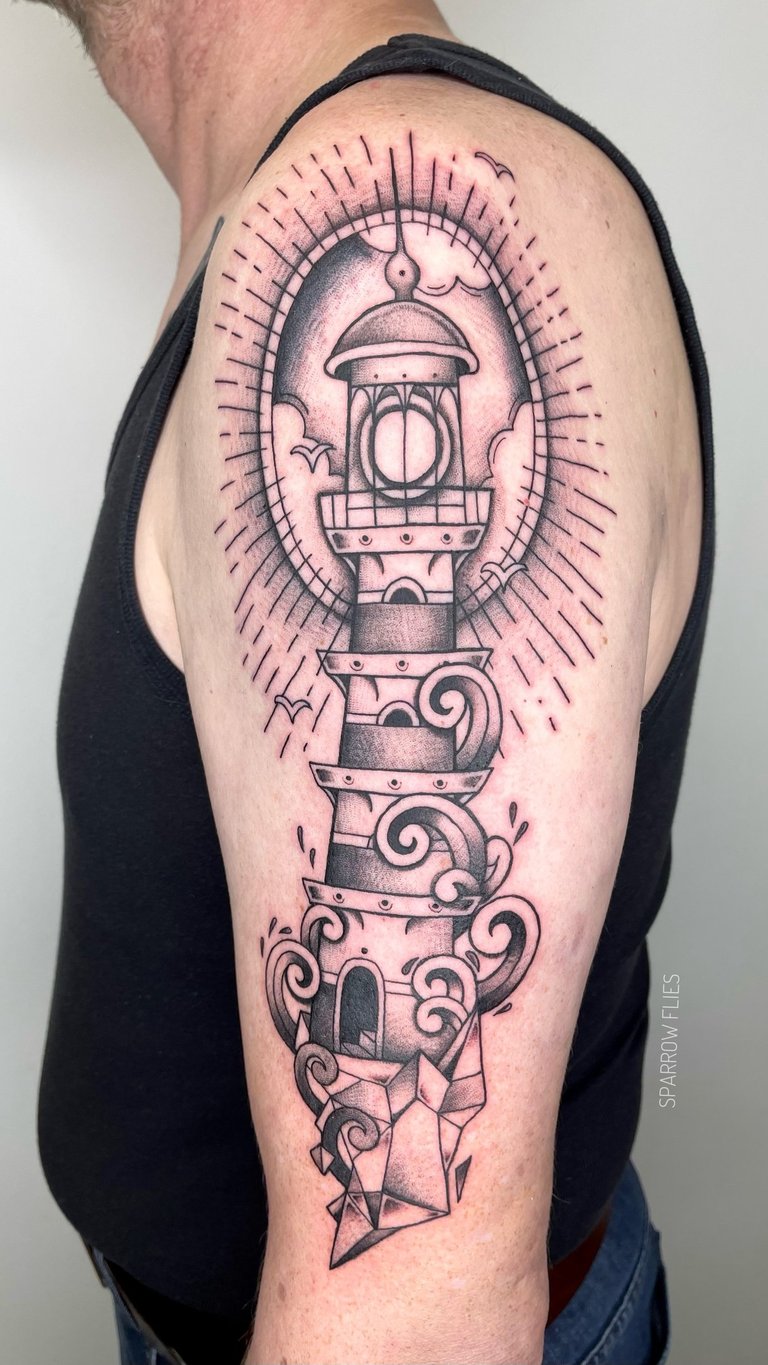 Old school lighthouse tattoo on upper arm