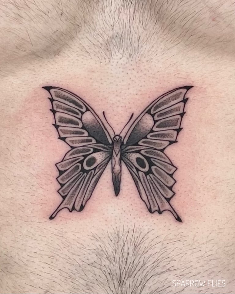 Blackwork butterfly tattoo on the stomach