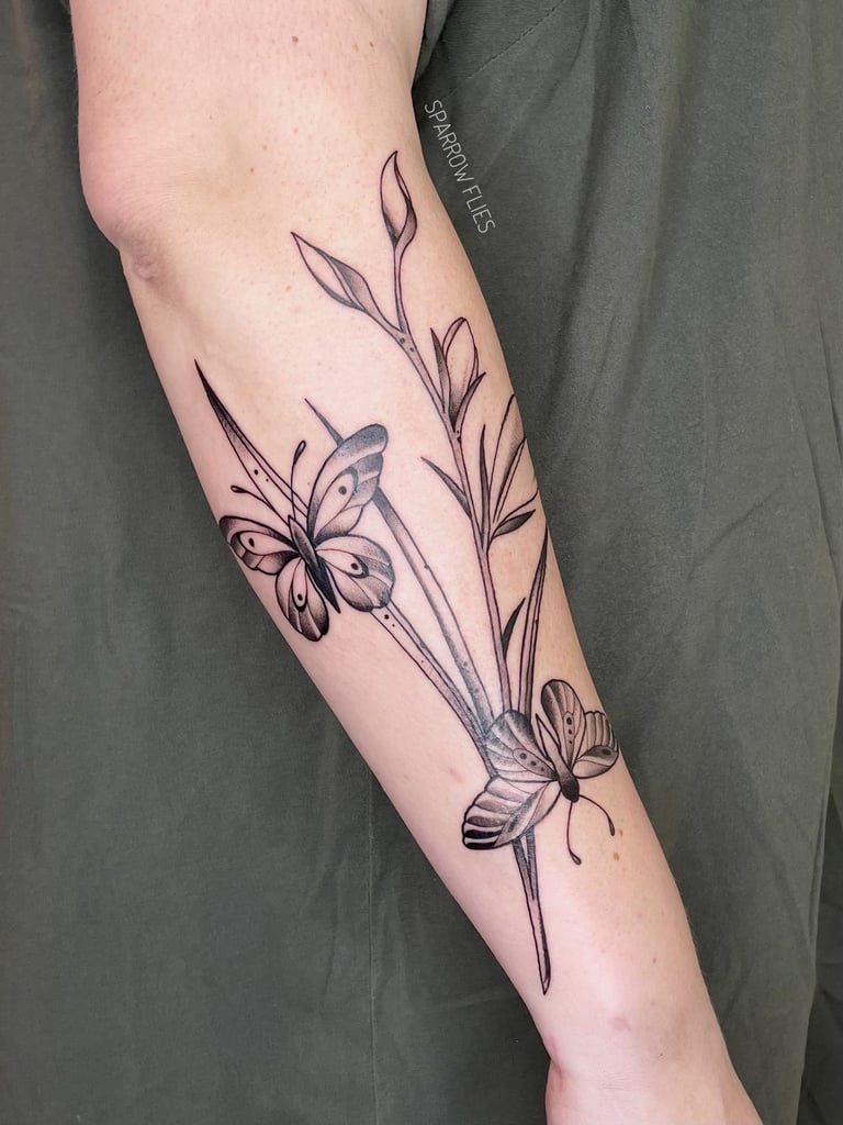 Neo-traditional butterlies and flowerrs tattoo on the forearm