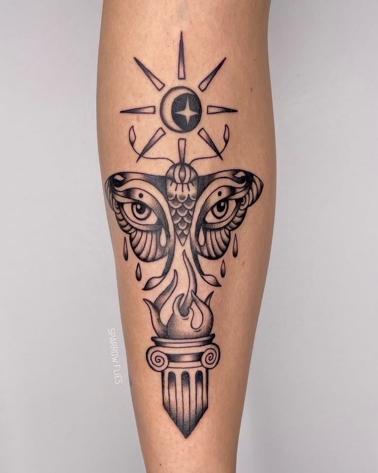 Old school moth, sun and moon and fire tattoo on the front of the shin