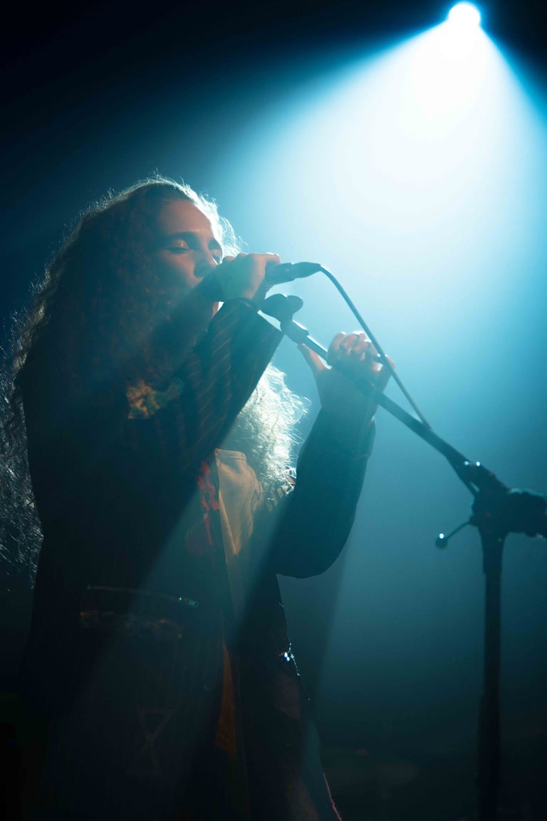 a blue stagelight shining down on a singer