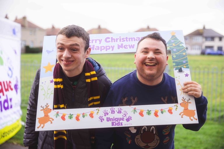 Two young men smiling through a physical frame