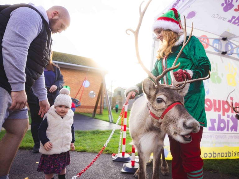 A young girl admiring a reindeer