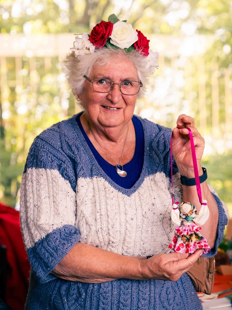 A lady in a flower crown holding a handmade polish doll