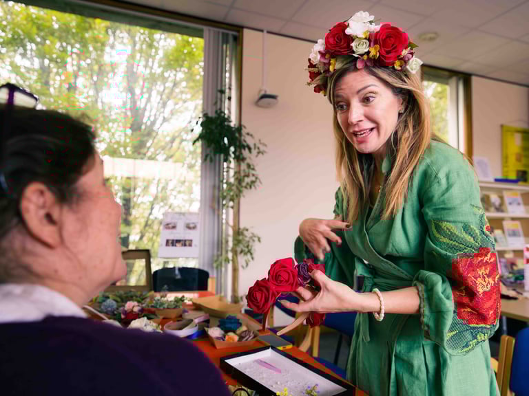 A lady in a flower crown and tranditional polish garb having a conversation