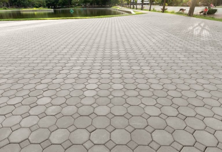 stamped concrete commercial driveway with a small lake
