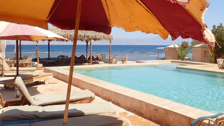 Pool sea view from sun umbrellas at Bedouin star