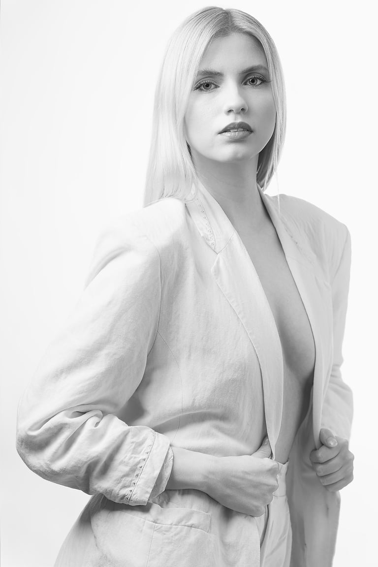 Schwarzweiß-Portrait einer Frau mit hellem Outfit vor hellem Hintergrund