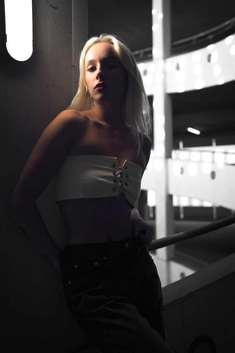 Portrait einer Frau mit dunkler Kleidung in urbaner Umgebung bei gedämpftem Licht