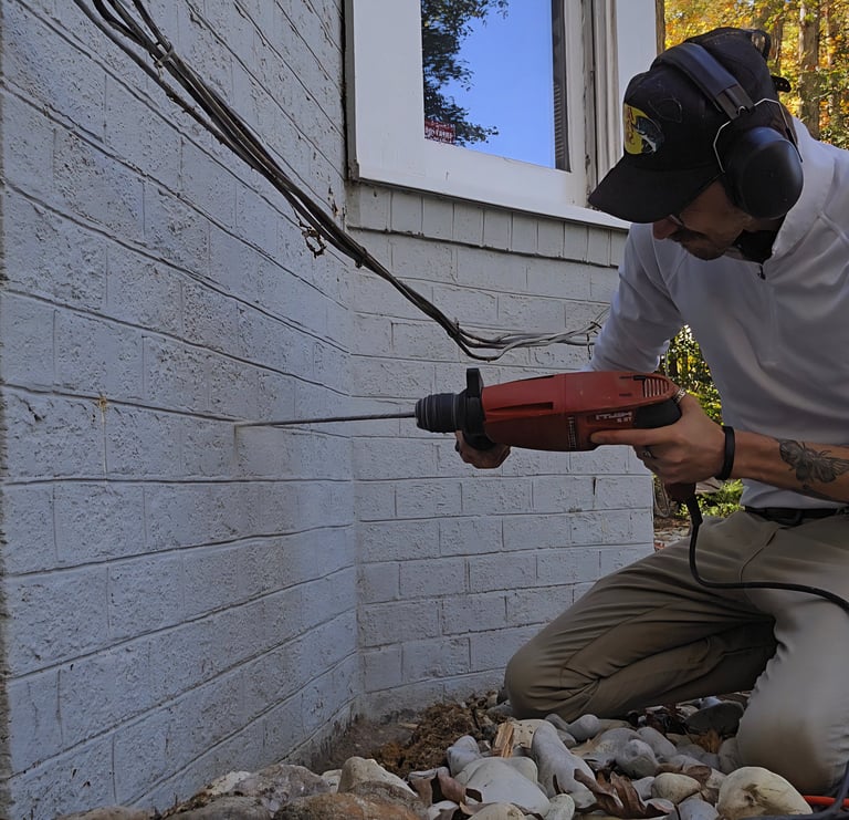 the owner of optimal termite & pest control treating a home for termites in richmond va