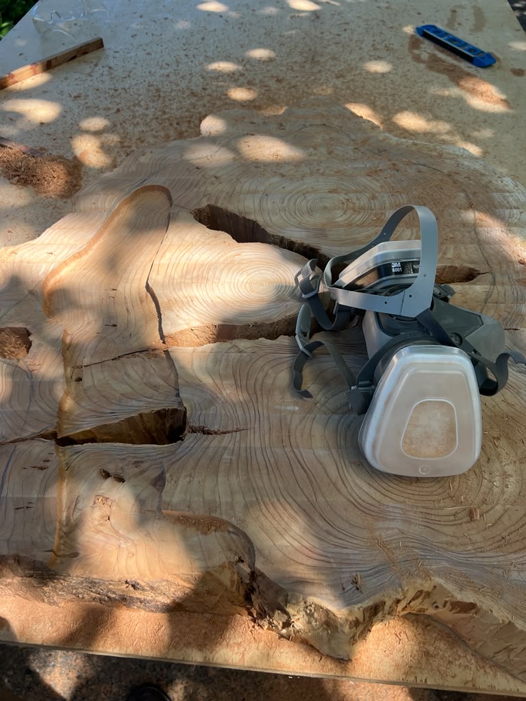 wooden slab with etching marks and a ventilation mask resting on it