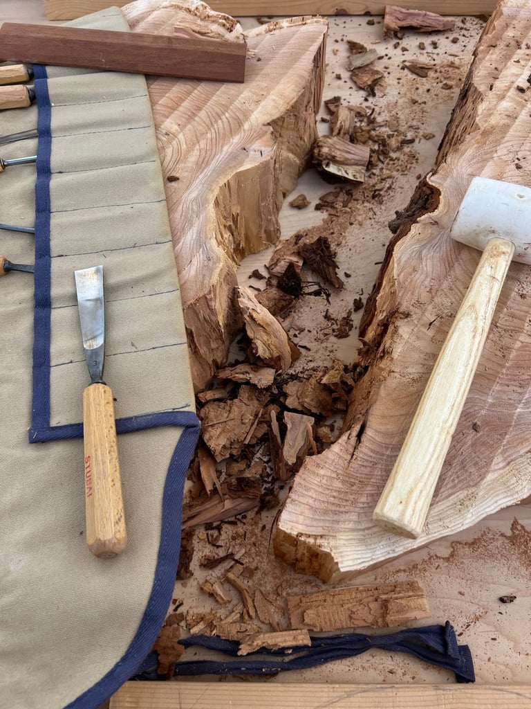 wood knives layed out on a slab of wood with wood chips and bark around it